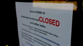 A local WorkOne employment office displays a sign on the front door saying it's closed due to COVID-19.
