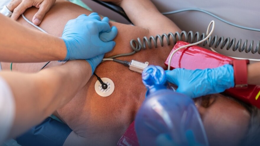 Paramedical personnel performing CPR on the unconscious man
