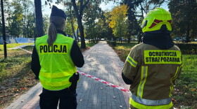 A police officer and a volunteer firefighter look down the street near a cordoned-off area following an attack on the Vocational School Complex No. 4 in Ostroleka, Poland, Wednesday, Oct. 7, 2026.