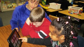 Christine Dunbar works with Parkwood Elementary students Jeffrey Coe and Shahiira Harrison on phonemic awareness skills using a tic-tac-toe game on the iPad.