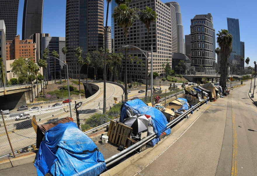 A homeless encampment on Beaudry Avenue as traffic moves along Interstate 110 in downtown Los Angeles on May 21, 2020.