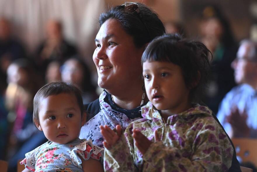 Ida Nelson holds Royal, 1, and Chael, 3, while attending the bill signing at Alaska Native Heritage Center on Thursday, July 28, 2022.