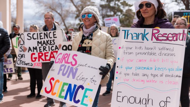 Protesters hold sign at the first Stand Up for Science rally held at the Santa Fe Roundhouse in March 2025.