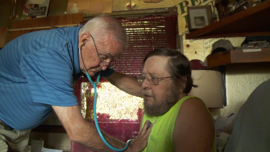 Dr. James Graham listens to a patient's heartbeat.