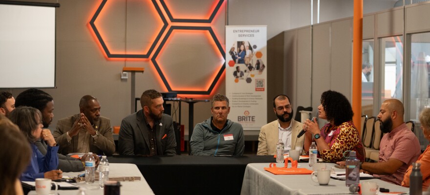 Community members gather around a table for discussion.