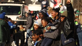 Seahawks fans pose for photos during the team's Super Bowl victory parade on Wednesday. Fans filled 4th Ave. to cheer their team on and catch a glimpse of their favorite players.