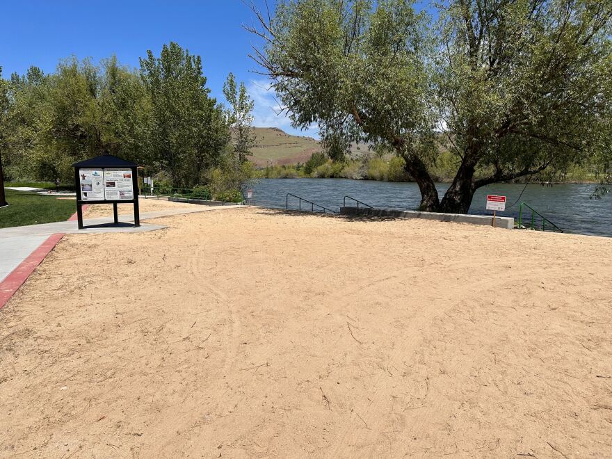  A sandy beach area with the Boise River in the background. 