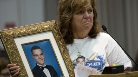 Sandra Boden holds a photo of her son, Jason, during a Task Force on Citizen Safety and Protection hearing. Prosecutors told Boden that Florida's Stand Your Ground law prevented them from filing charges against the person who shot and killed Jason.