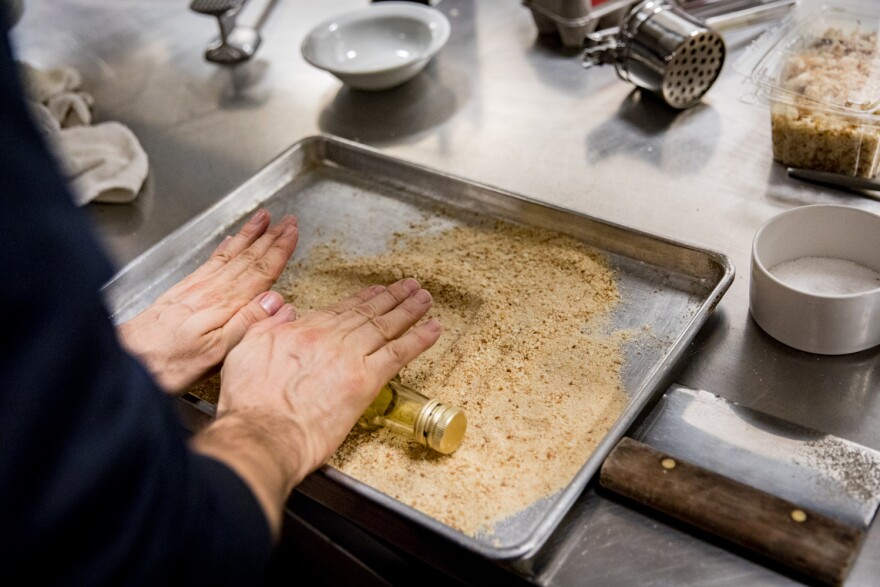 NPR's food processor wasn't producing a fine enough texture for Bottura, so he decided to manually crush the crumbs by rolling over them with a glass bottle from the kitchen.