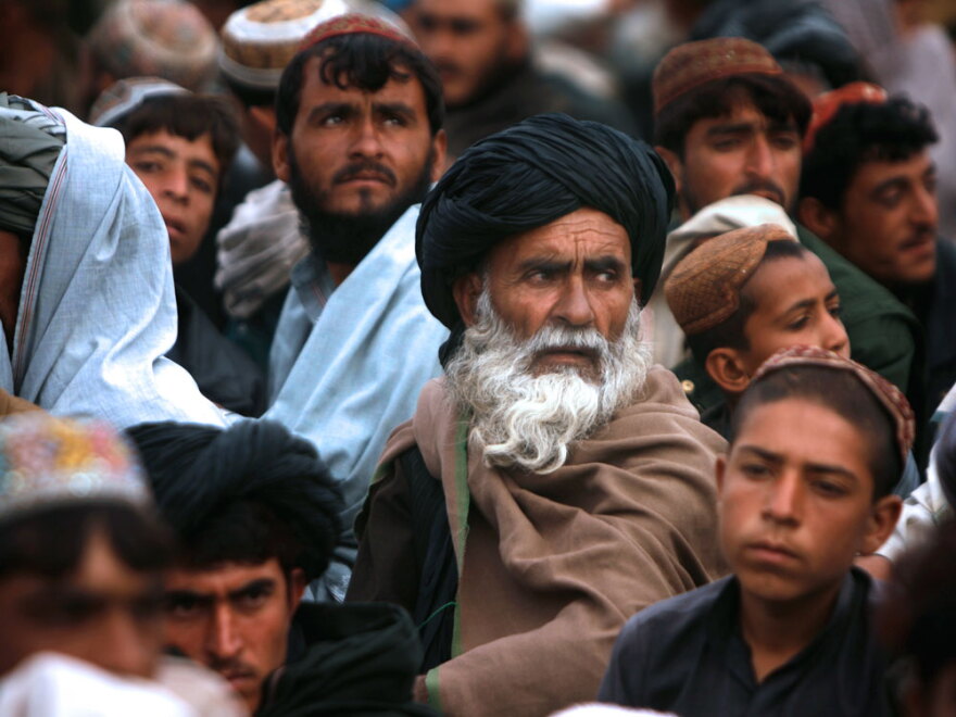 Afghans gather to attend an official flag-raising ceremony in Marjah on Feb. 25. Afghanistan's red, green and black flag was raised over Marjah by the governor of Helmand province, watched over by military commanders and a crowd of residents.