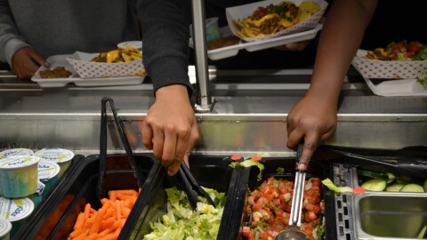 Students at Rosedale Middle School in Kansas City, Kansas, serve themselves local produce on their lunch tray.