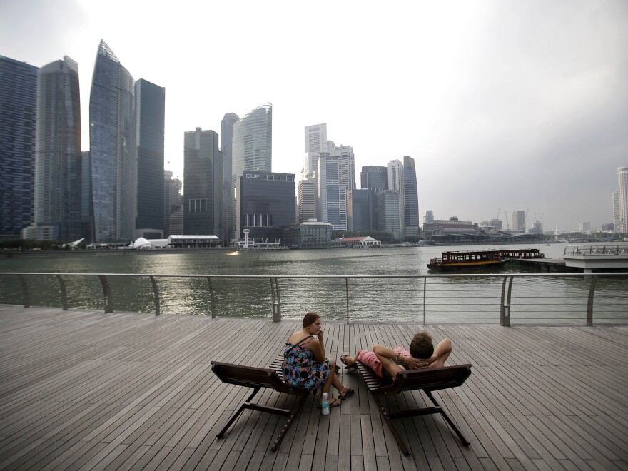 A couple enjoys the view of Singapore's financial center. Conservatives saw Singapore as a free-market success story, but Lee Kuan Yew's government played a big role in the economy.