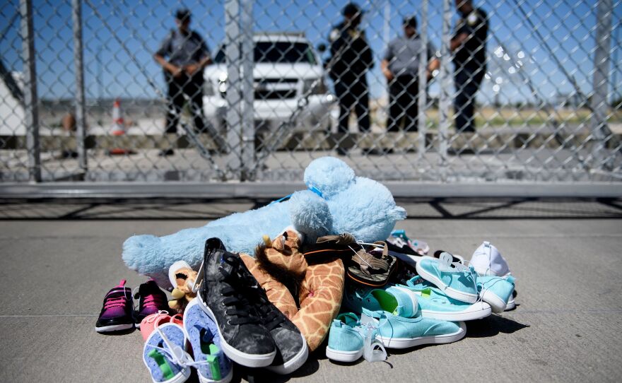 Security personnel stand before shoes and toys left at the Tornillo Port of Entry, where minors crossing the border illegally have been housed after being separated from adults, back on June 21.