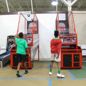 Kids play a basketball arcade game during camp at a recreation center in Baton Rouge on June 2, 2026.
