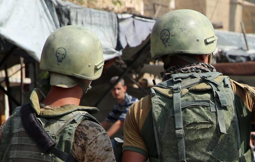 A picture taken during a press tour provided by the Russian Armed Forces on Sept. 15, 2017, shows Russian soldiers standing guard in a central street in Syria's eastern city of Deir Ezzor, as locals pass by. (Dominique Derda/AFP/Getty Images)