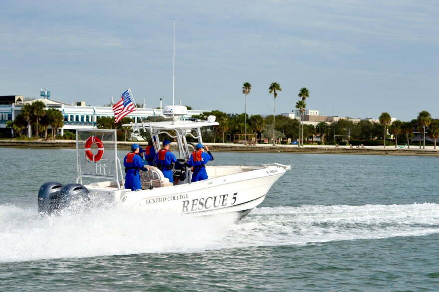 People in blue wet suits on boat 