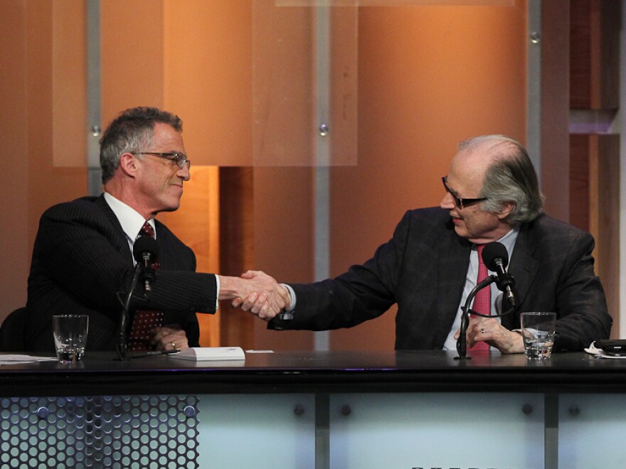 Debaters Frederic Mishkin and John Taylor celebrate their win after arguing that the U.S. doesn't need a strong dollar policy.