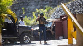  A presidential guard gestures on Wednesday at the entrance to the Port-au-Prince home of President Jovenel Moise, who was assassinated by gunmen there earlier in the morning.
