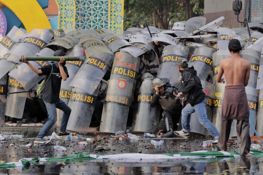 Protesters clash with police during a rally against the passing of a revision of a military law that will allow military officers to serve in more government posts without resigning from the armed forces, in Surabaya, East Java, Indonesia, March 24, 2025. (AP Photo/Trisnadi)