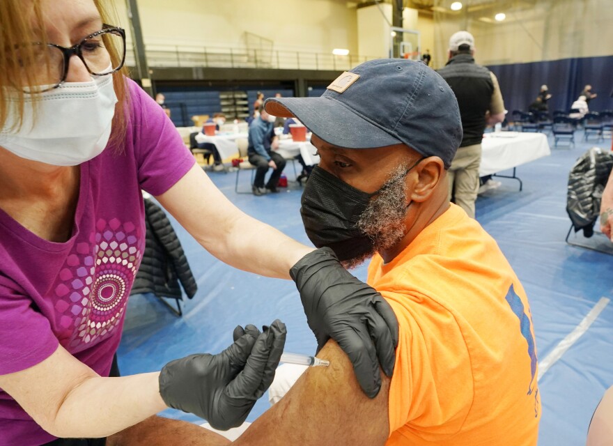 Michael Elliott receives the Johnson and Johnson COVID-19 vaccination from Barbara Scott, at St. Louis Community College at Forest Park in St. Louis on Thursday, March 25, 2021. The mass vaccination was able to put 3000 shots into arms in eight hours. 