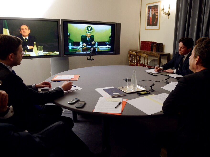 Former French President Nicolas Sarkozy (R) and Elysee's diplomatic adviser for U.S. Damien Loras (2ndR) take part in a video conference with President Barack Obama (on screen) focused on Syria, Iran and Afghanistan situations, at the Elysee palace on April 12, 2012 in Paris.