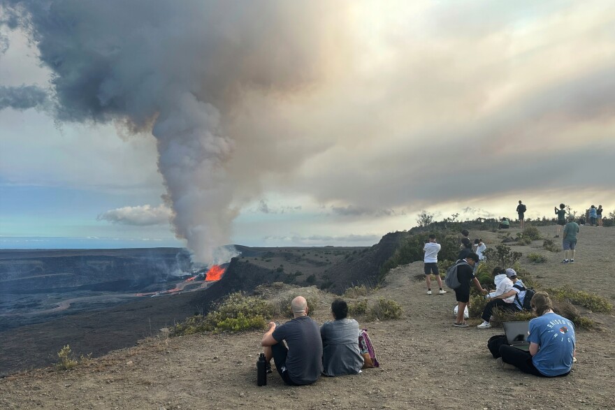 People watch the Kīlauea volcano on Hawaiʻi Island as it erupts on Sunday, July 20, 2025. (AP Photo/Anna Johnson)