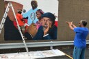 Artist William Burton Jr. talks with Black Rep founder Ron Himes as he works on a mural on the side of the theater company's office building on October 31, 2016.