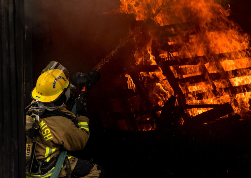 A firefighter tackles a practice blaze set inside a shipping container. 