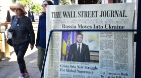 Pedestrians walk past a newspaper stand with copies of The Wall Street Journal and a front page report on Russia's invasion of Ukraine are being sold in Los Angeles, California.