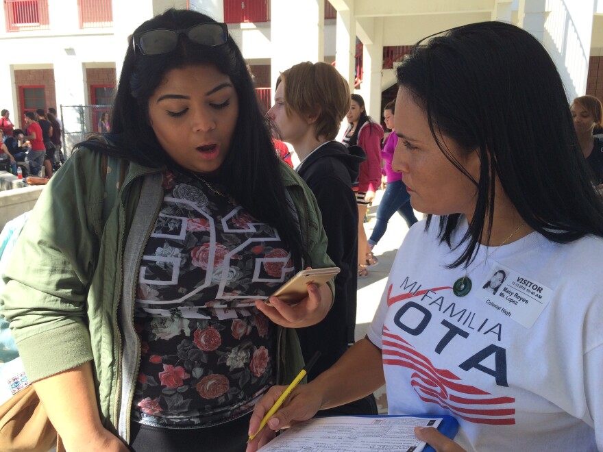 Mairy Reyes (right), a civic engagement officer with the nonprofit group Mi Familia Vota, registers students to vote at Colonial High School in Orlando, Fla.