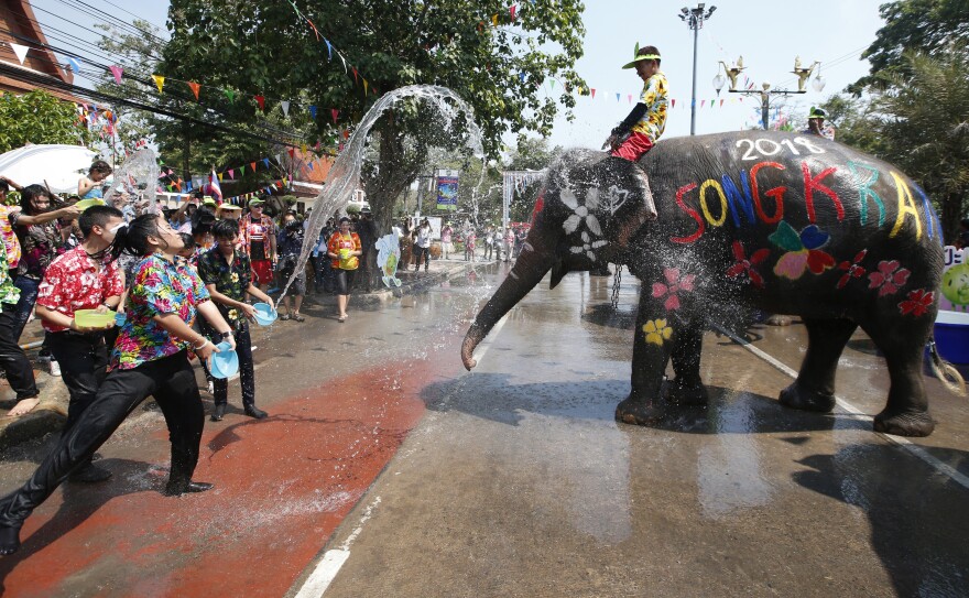 File - Tourists splash water to an elephant, ahead of the Buddhist New Year, known as Songkran, in Ayutthaya province, central Thailand Wednesday, April 11, 2018. The three-day new year festival will start on April 13.