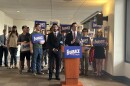 Republican gubernatorial candidate James Fishback speaks at a podium surrounded by supporters and "Fishback for Florida" signs during a news conference inside a government building.