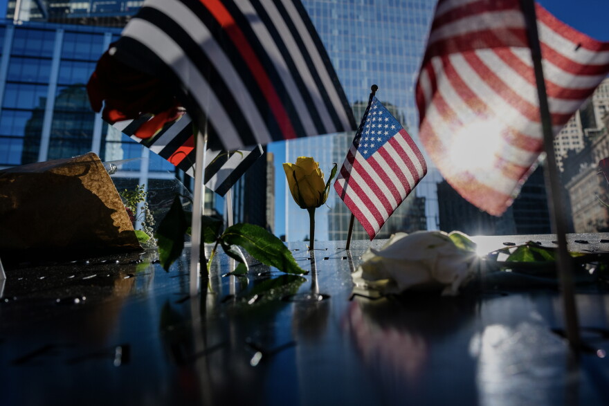 Flags and roses are placed on the edge of the 9/11 Memorial Pools on the 25th anniversary of the September 11 World Trade Center attacks, Friday, Sept. 11, 2026, in New York.