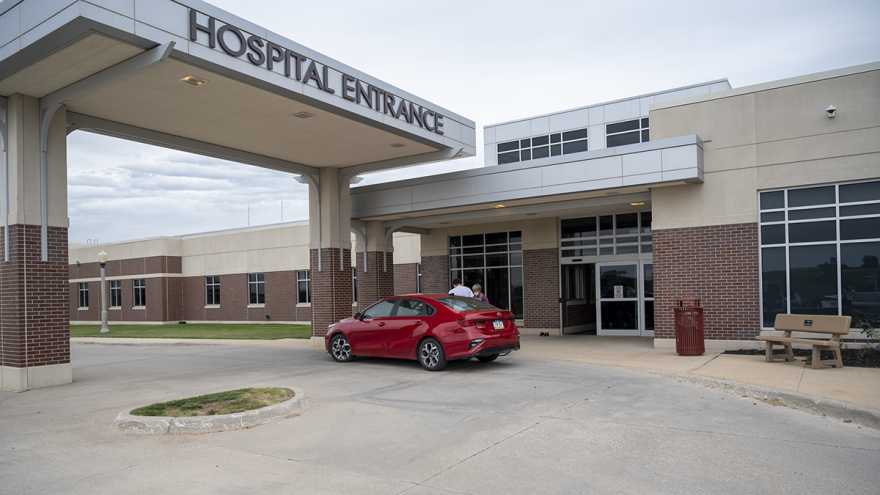 A patient exits a car at the entrance of Iowa’s Crawford County Memorial Hospital.