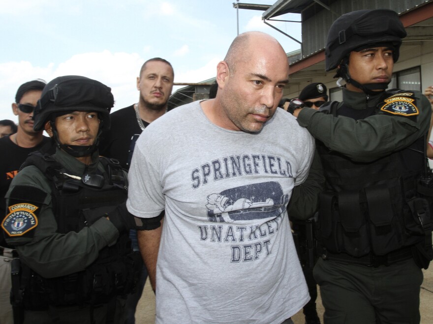 Joseph Manuel Hunter (center) is escorted by Thai police commandos to Police Aviation Division after being arrested, in Bangkok on Thursday.