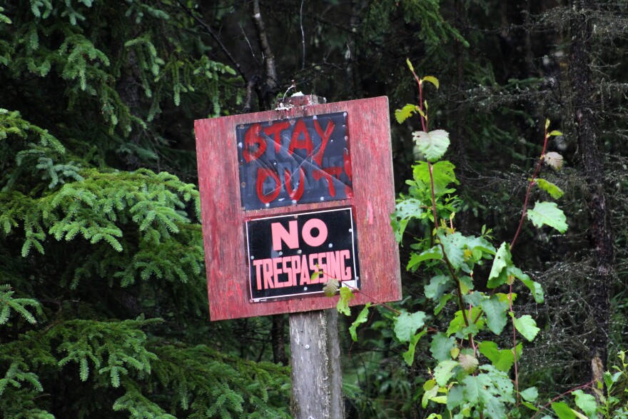 A "No Trespassing" sign pokes above the treeset at the intersection of Huske Street and Betty Lou Drive on Wednesday, July 22, 2026 in Sterling, Alaska.