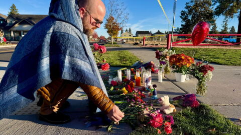 A person places flowers at a makeshift memorial on the other side of Silver Rail Elementary School in Bend, Ore., on Friday, Oct. 16, 2026, a day after a deadly shooting. (AP Photo/Haven Daley)