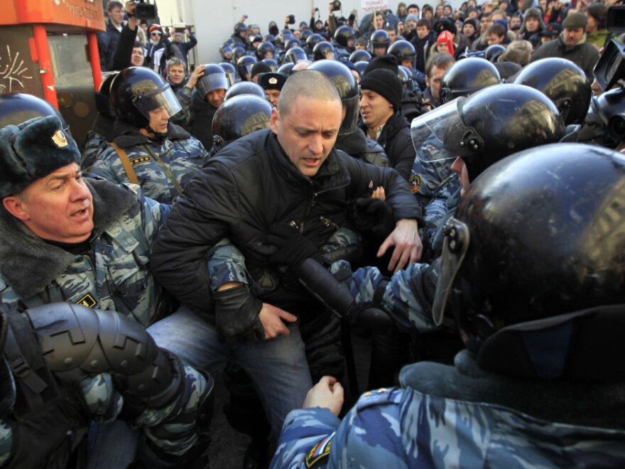 Police officers detain opposition leader Sergei Udaltsov after the rally Saturday.