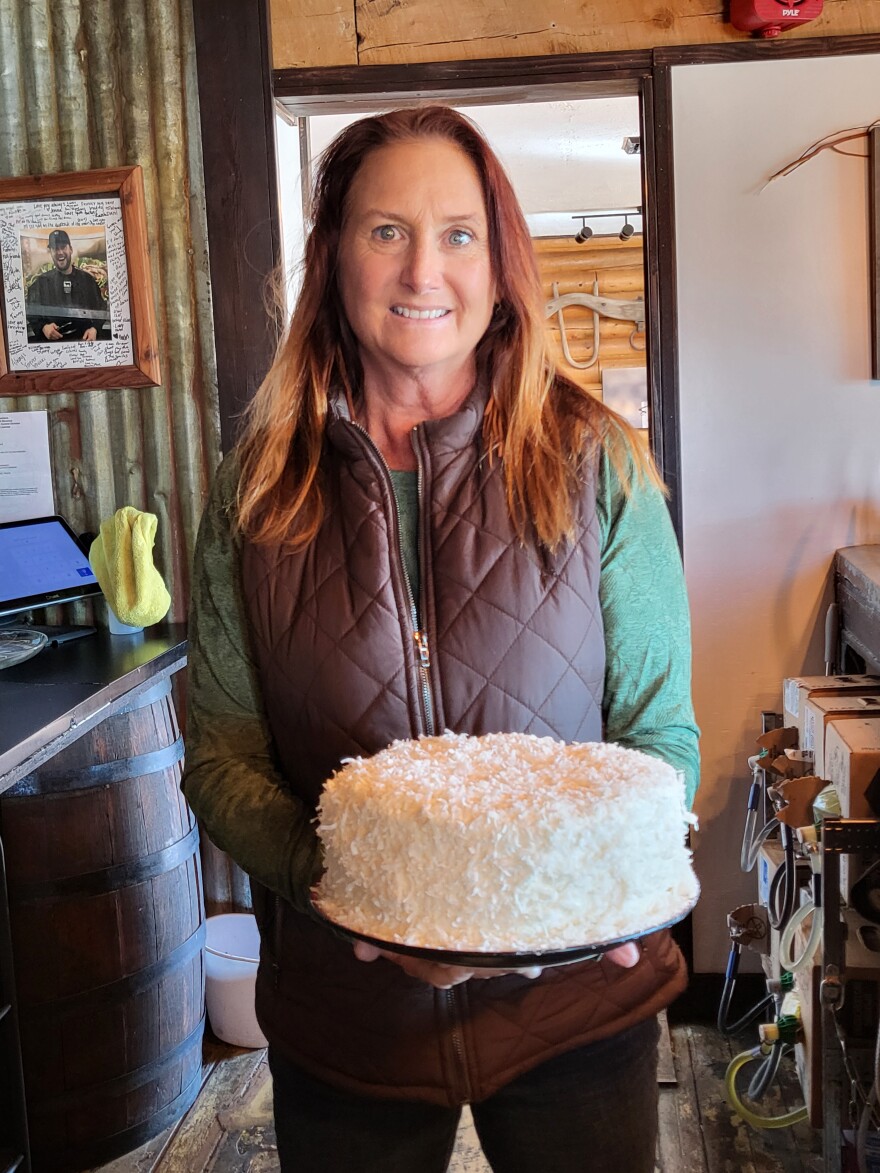 Melody Redding plays many roles at Jesse Pepper’s Smoke Shack. Not only does she run the business and work the front of the house, she also grows much of the vegetables offered at the restaurant along with doing all the baking. Here she holds her coconut cake.