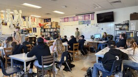 Students in a classroom at tables.