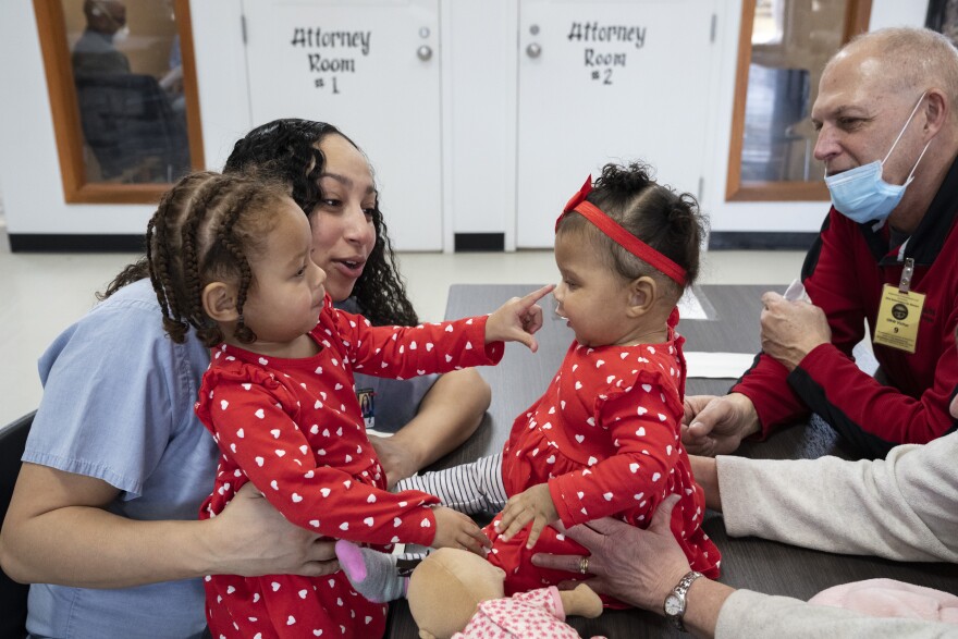 Abby Small holds her 2-year-old daughter Quam Judah while her father and mother Tom and Terri Small hold another of Smalls daughter’s Gianna Judah while the two children meet each other for the first time in their lives at the Ohio Reformatory for Women, in Marysville, Ohio, on Thursday, March 3, 2022.