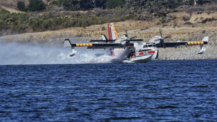 A super scooper aircraft gets water from Lake Cachuma to drop on the Alisal Fire