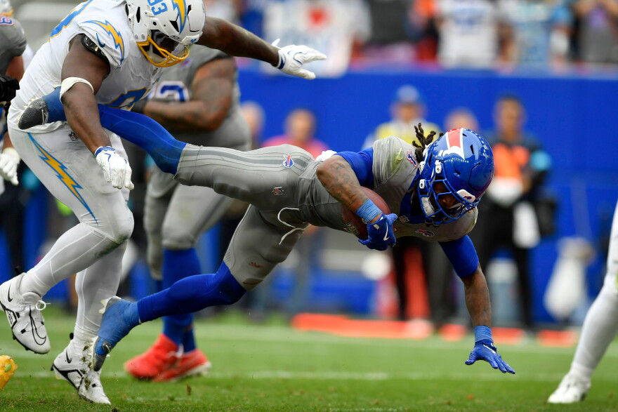 Buffalo Bills running back James Cook III (4) scores a touchdown ahead of Los Angeles Chargers defensive tackle Teair Tart, left, during the second half of an NFL football game, Sunday, Sept. 27, 2026, in Orchard Park, N.Y.