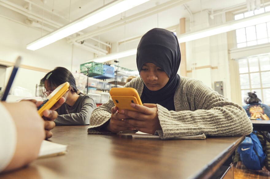 After measuring heat levels around their playground, science students at Brooklyn's J.H.S 223, including Fatiha Khan, seen here, calculate the overall average temperatures of four types of surfaces.