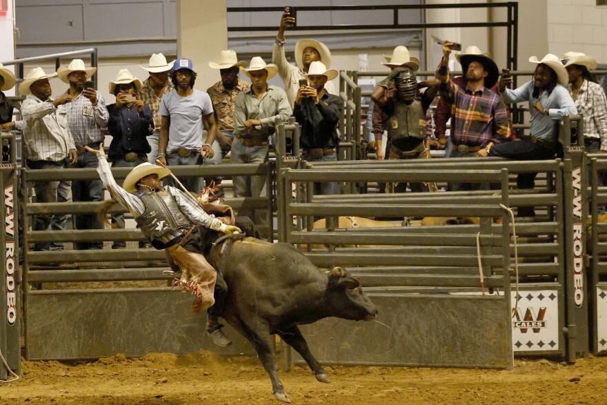 Kaleb Lewis of Kaufman, Texas, competes in bull riding during Texas Black Invitational Rodeo at Fair Park Coliseum, Saturday, July 26, 2025, in Dallas.