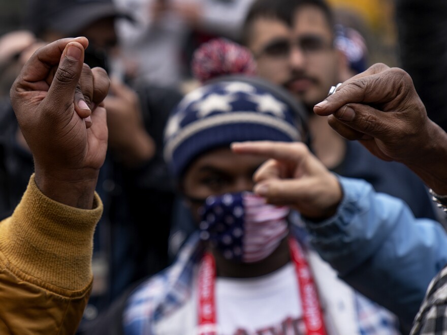 Biden and Trump supporters gesture at one another as they argue while Trump supporters demonstrate against the election results in Detroit on Nov. 5, 2020. [David Goldman / AP]