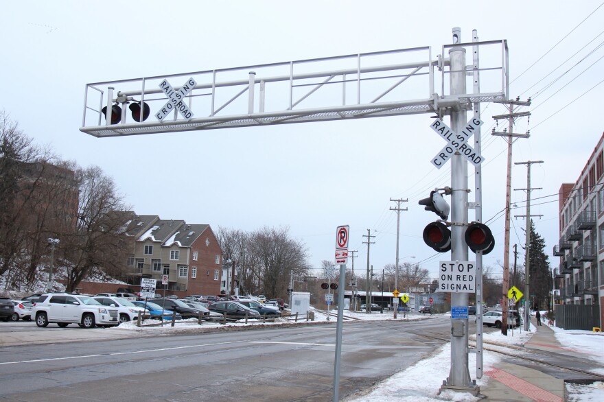 Street and railroad crossing with lights and signs.