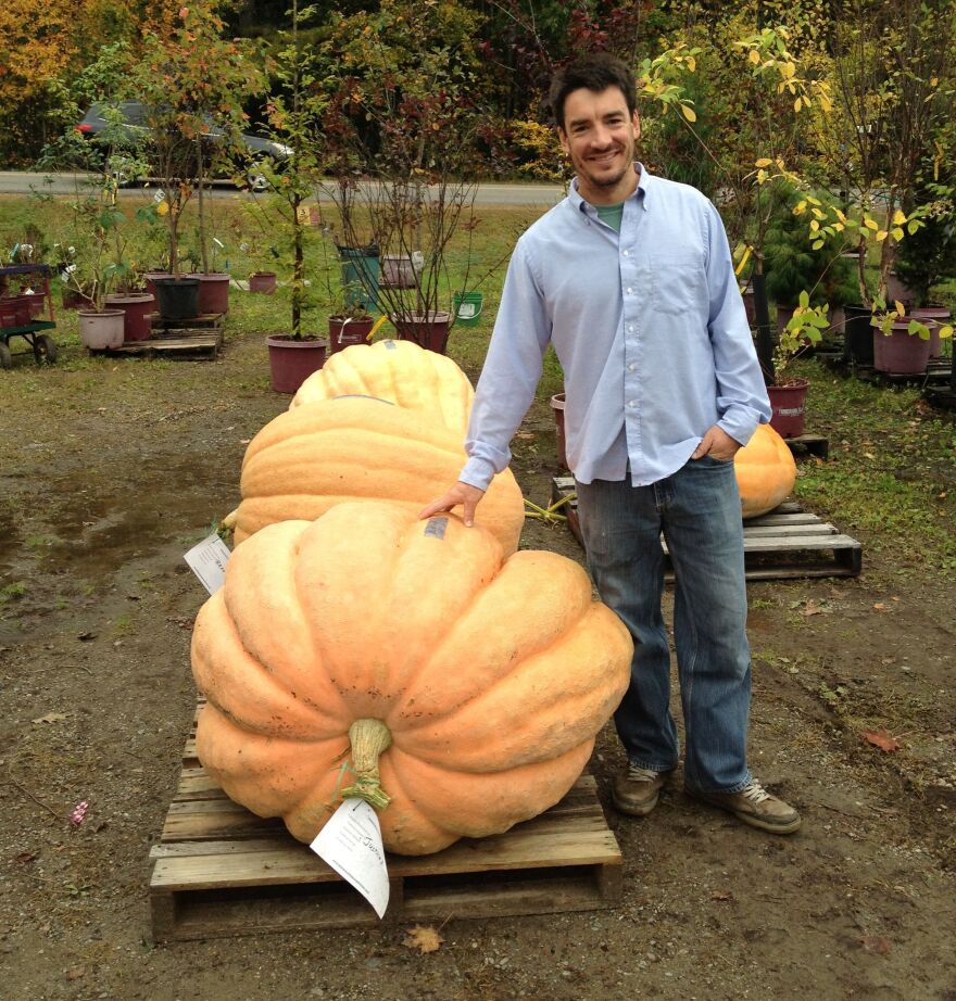 Topher Mallory stands next to the pumpkin he turned into a first-place-winning powerboat.