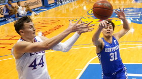 Kentucky guard Kellan Grady (31) blocks a pass intended for Kansas forward Mitch Lightfoot (44) during the first half of an NCAA college basketball game Saturday, Jan. 29, 2022, in Lawrence, Kan. (AP Photo/Charlie Riedel)