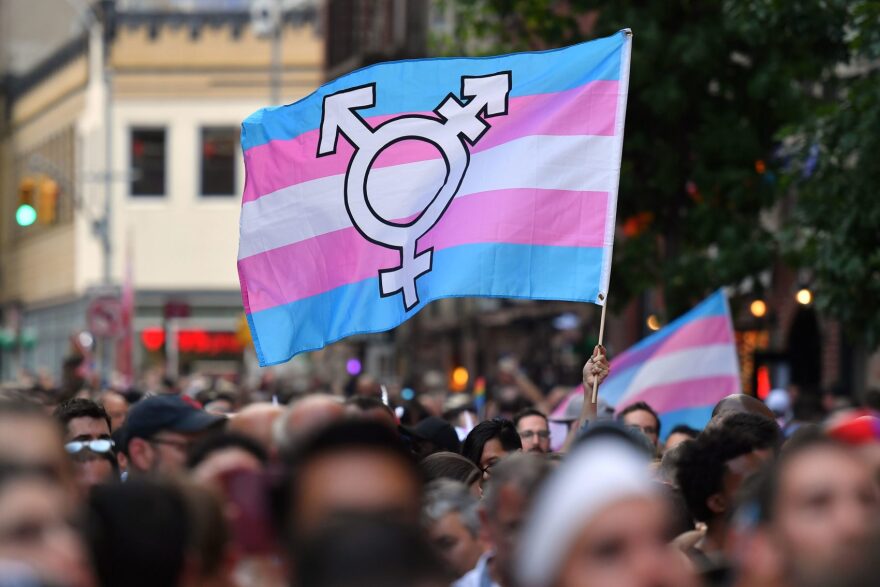 A person holds a transgender pride flag as people gather outside the Stonewall Inn for a rally to mark the 50th anniversary of the Stonewall riots. (Angela Weiss/AFP/Getty Images)